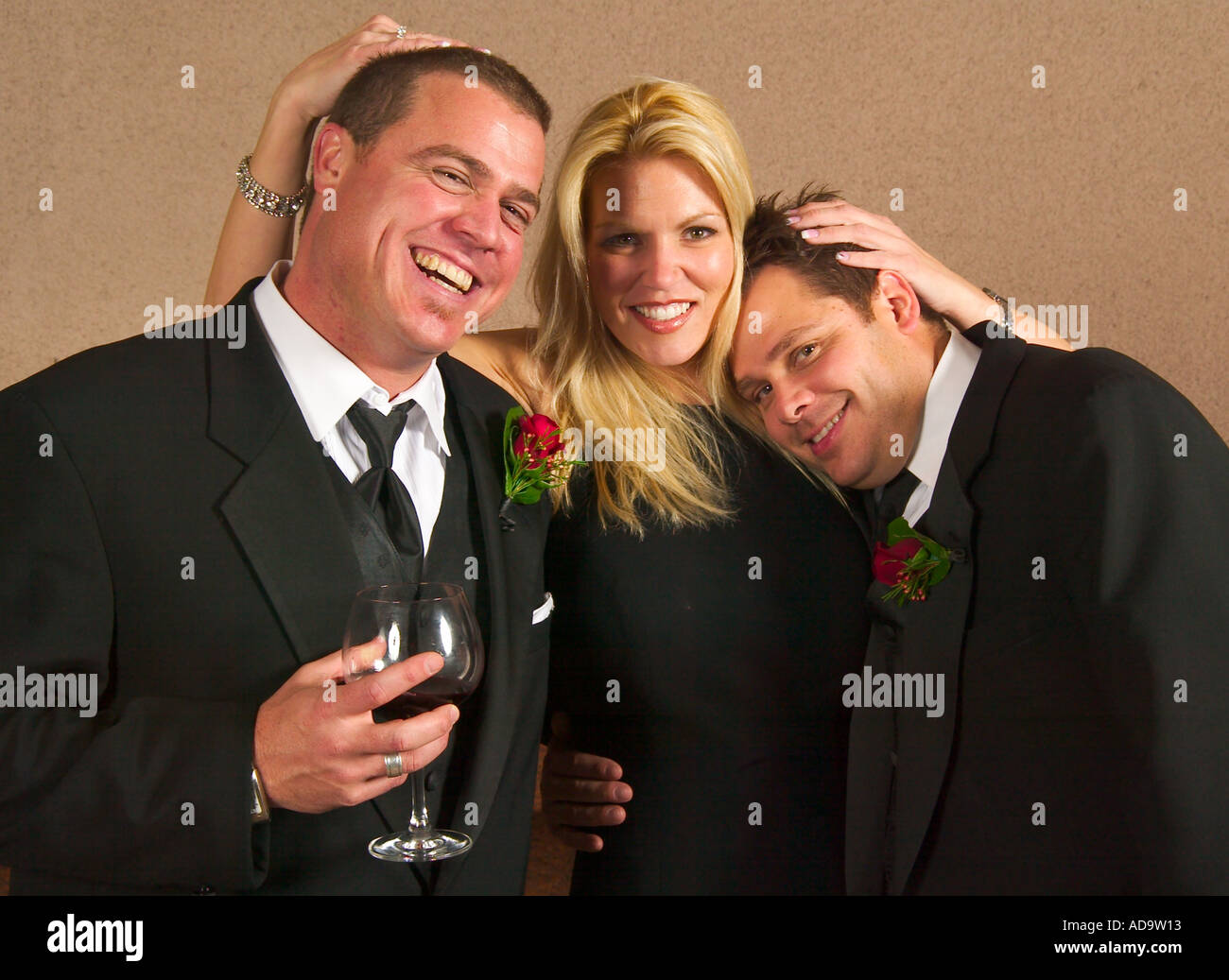 A happy blonde gets two of her fellow guests to pose at a formal wedding reception in Costa Mesa California Stock Photo