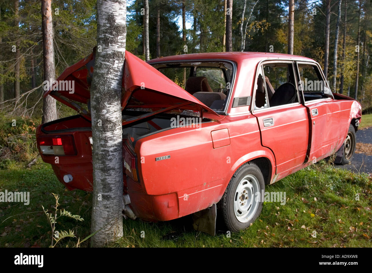 The busted rear end of a red Lada which hit a tree , Finland Stock Photo