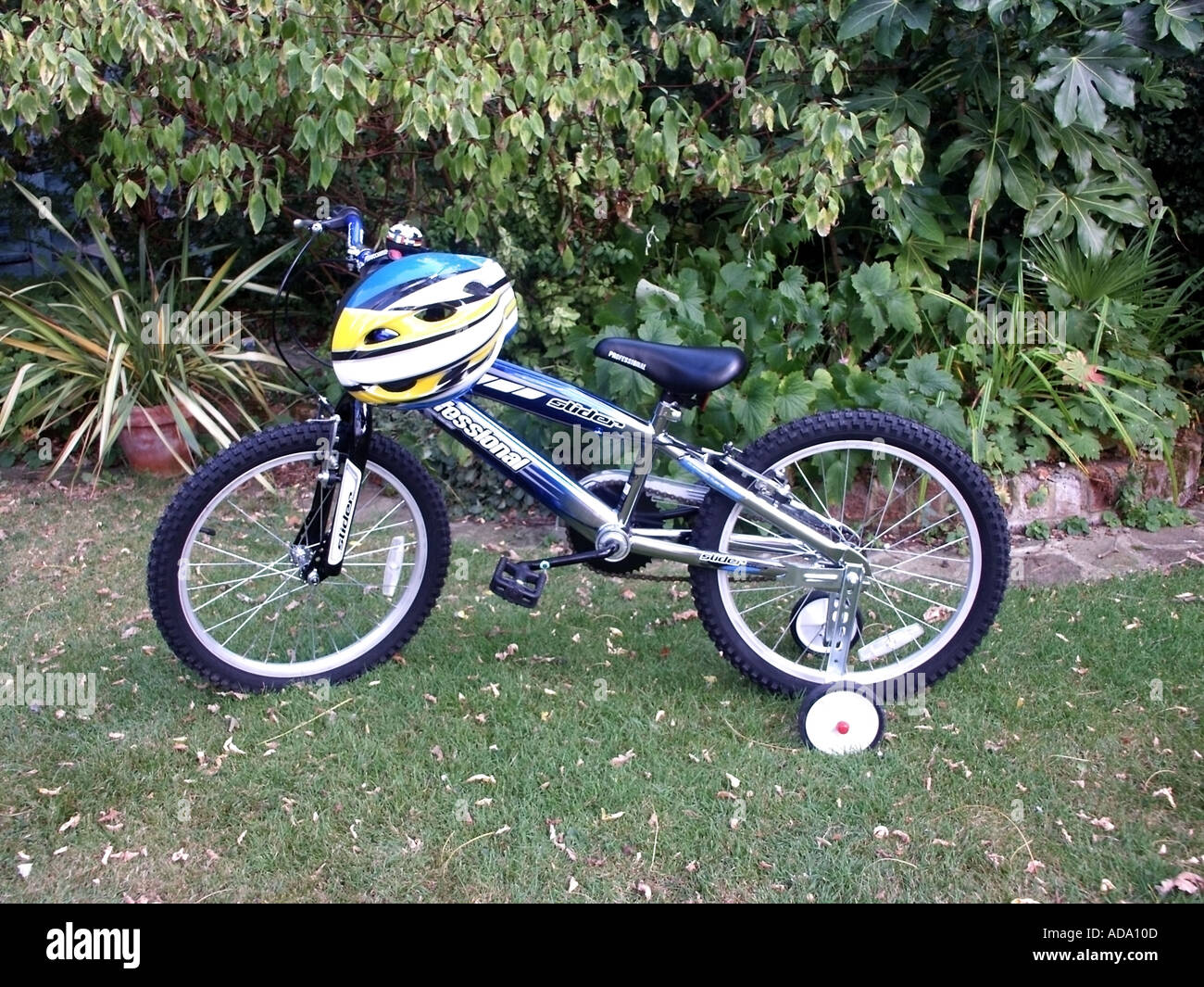 New boys bike fitted with stabilisers parked in garden complete