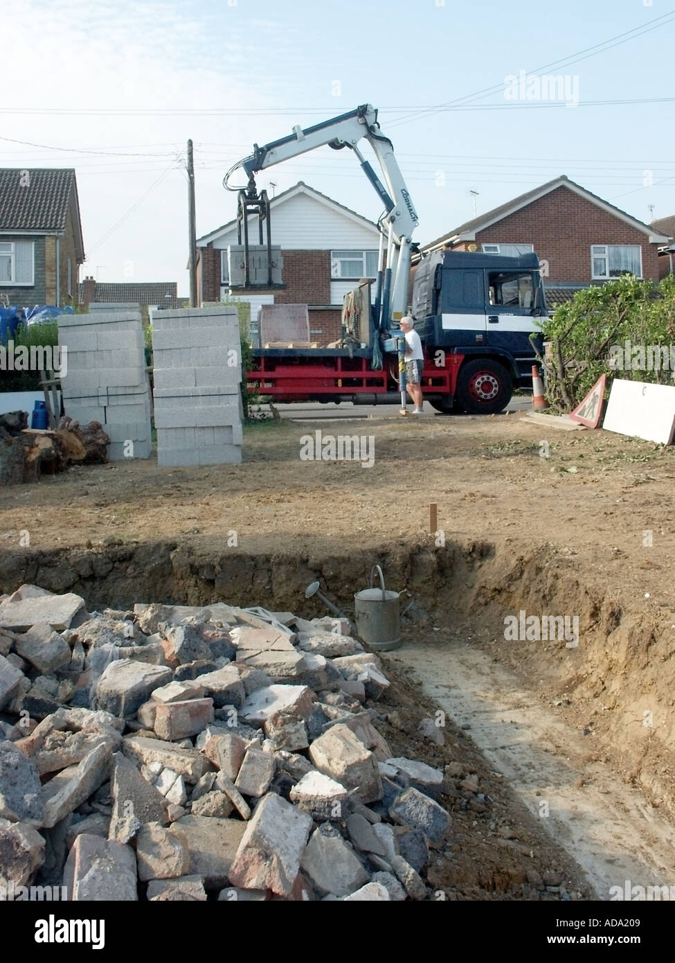 Crane offload delivery lorry blocks for walls new detached house trench
