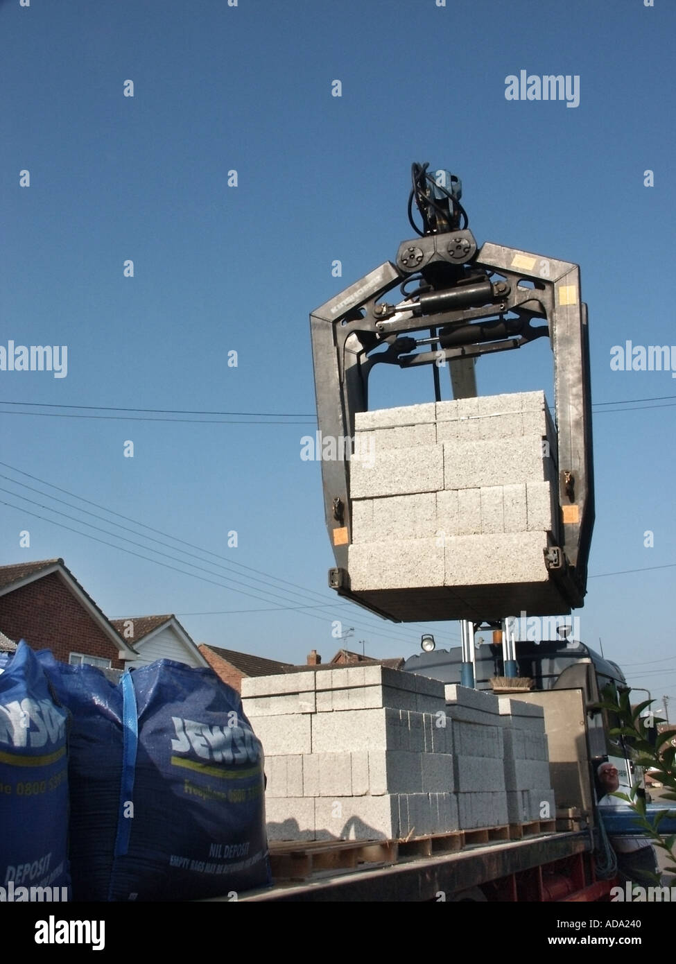 Mechanical unloading lorry truck of load of concrete blocks lifted off