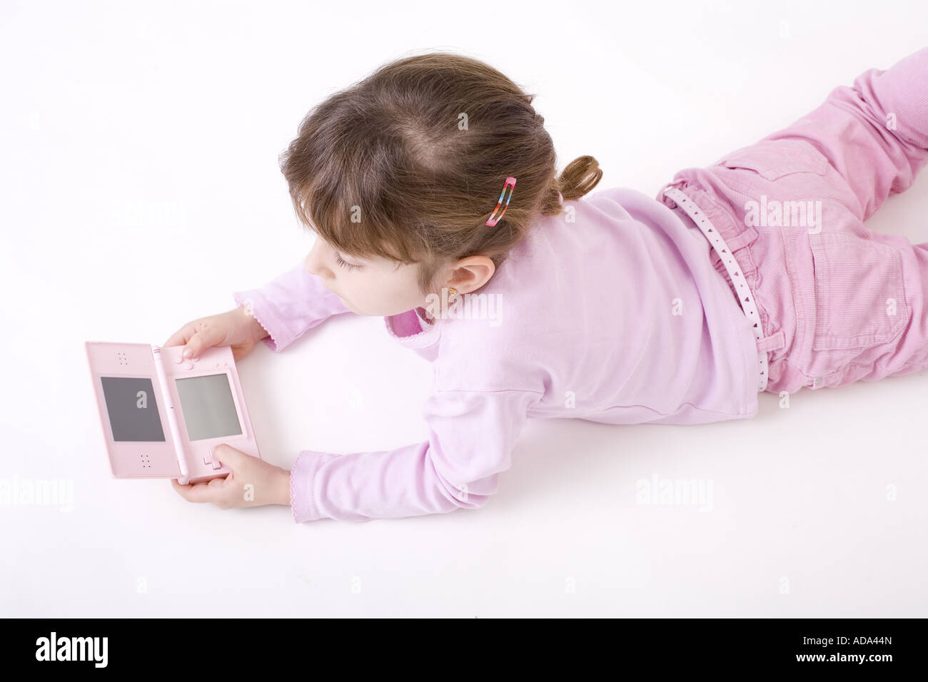 girl in pink clothes with a pink Gameboy Stock Photo