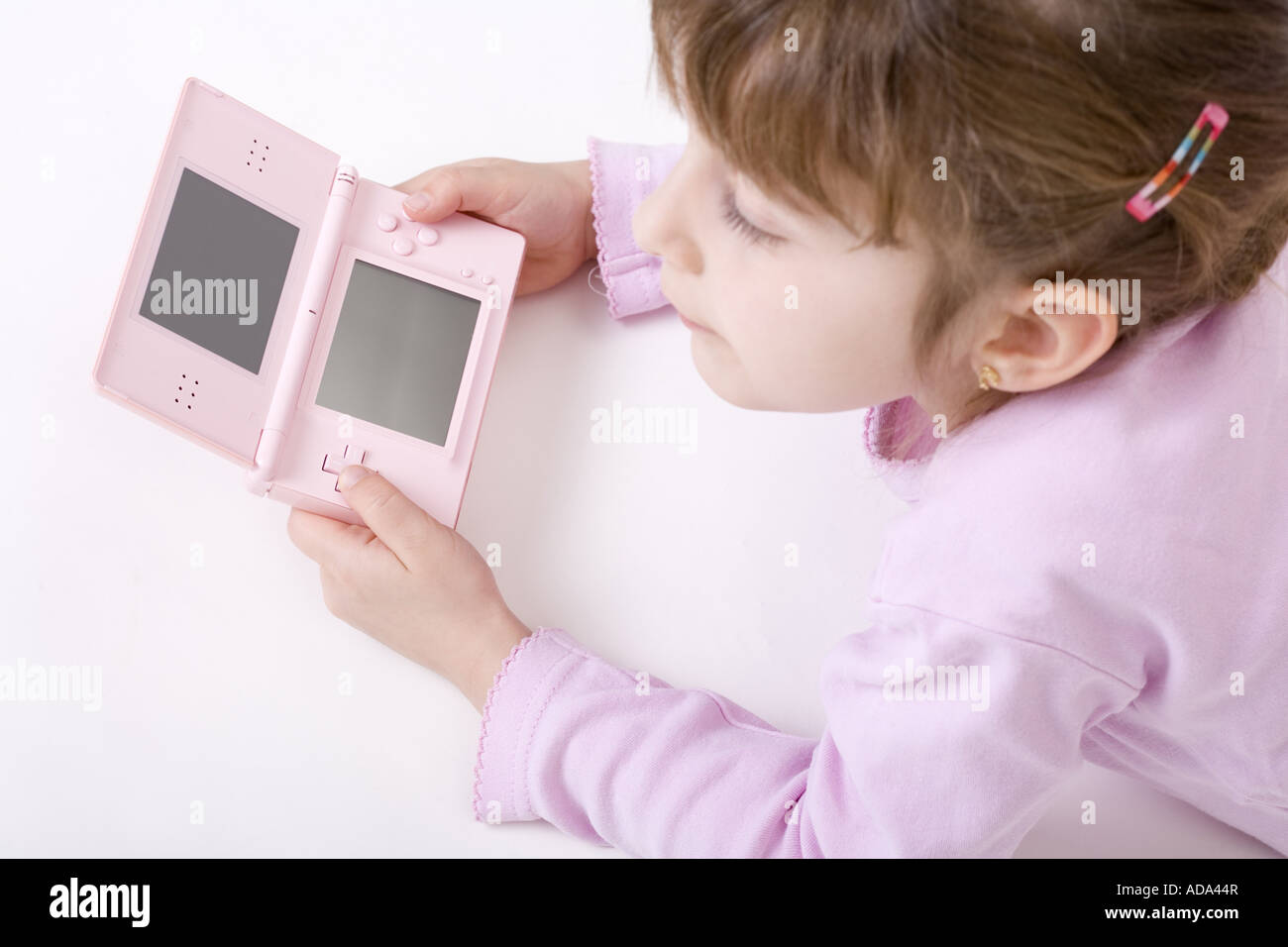 girl in pink clothes with a pink Gameboy Stock Photo