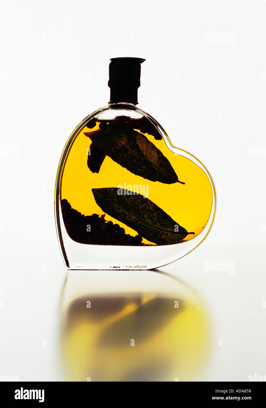 Olive oil in heart shaped jar on white background Stock Photo