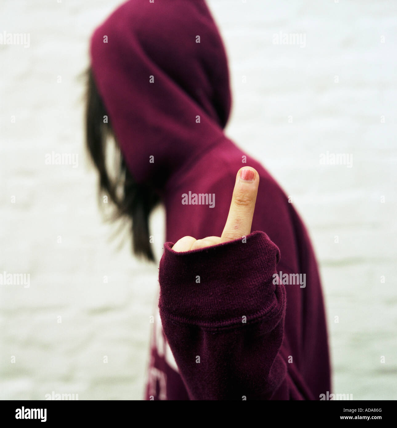 Girl in hood showing middle finger Stock Photo