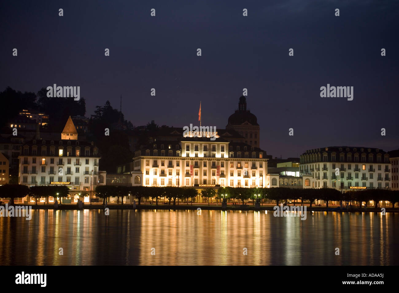 View over Lake Lucerne to illuminated Hotel Schweizerhof Luzern at