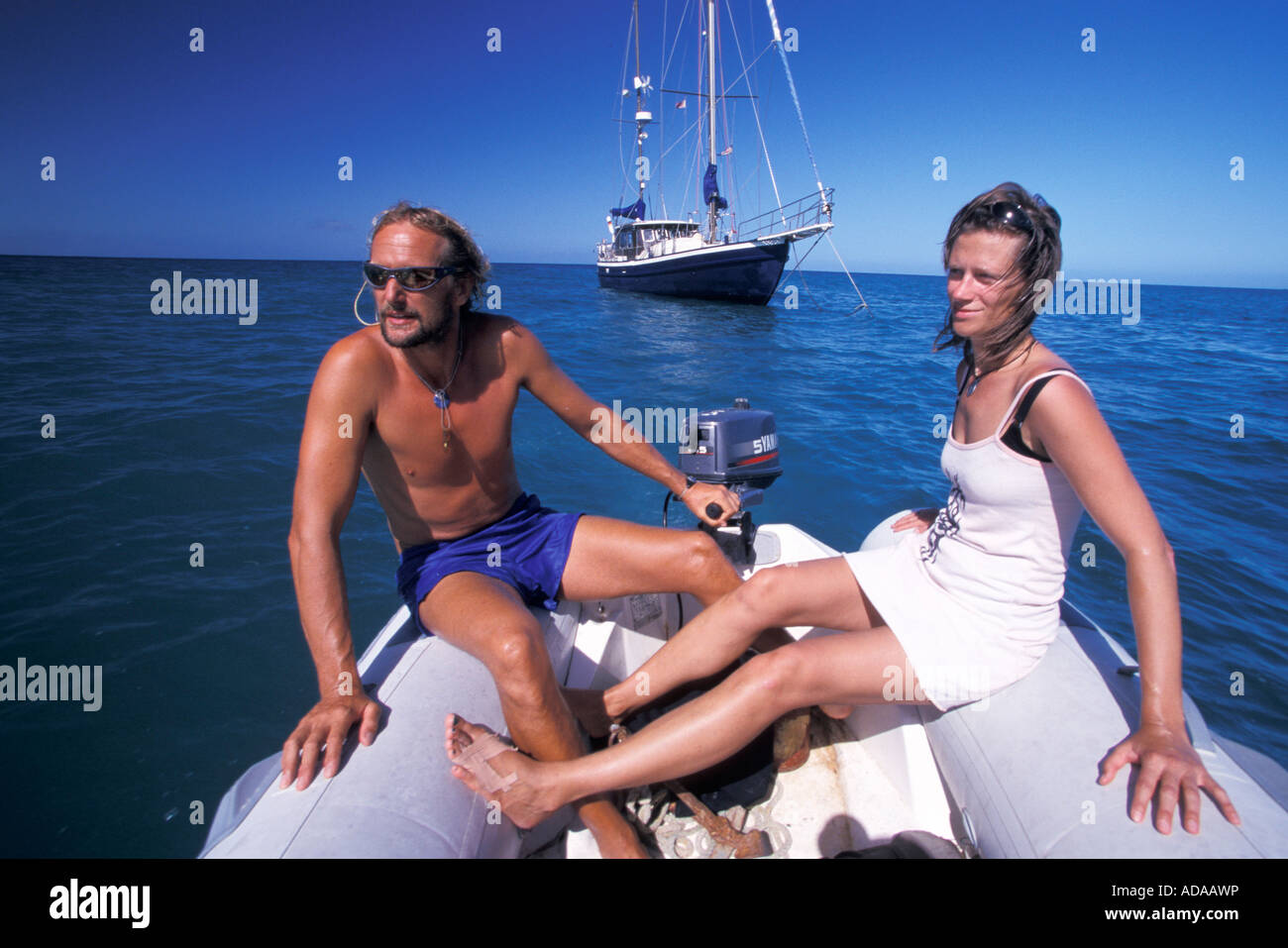 Couple on dinghy yacht in background Pigeon Point Tobago Trinidad And Tobago Stock Photo