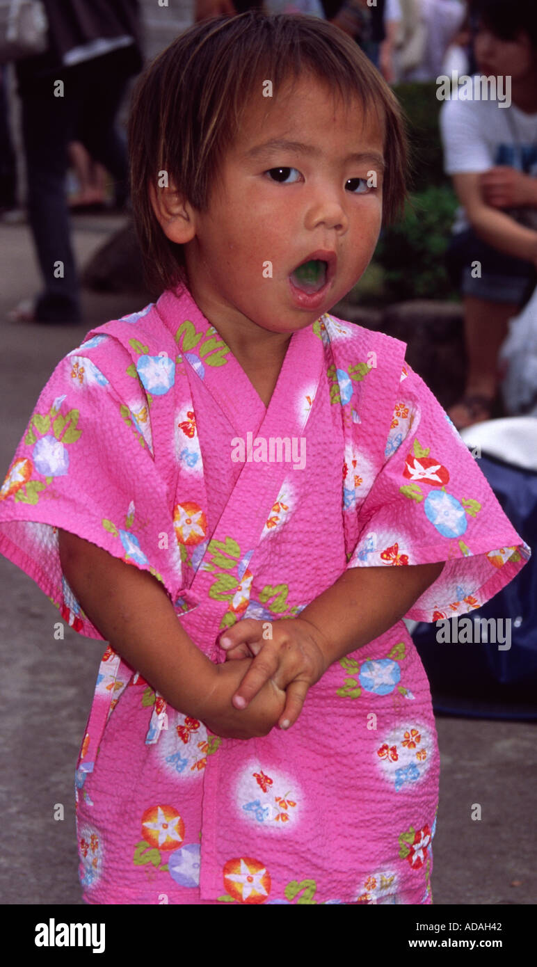 Young Japanese child wearing pink kimono yawns. Japan. Stock Photo