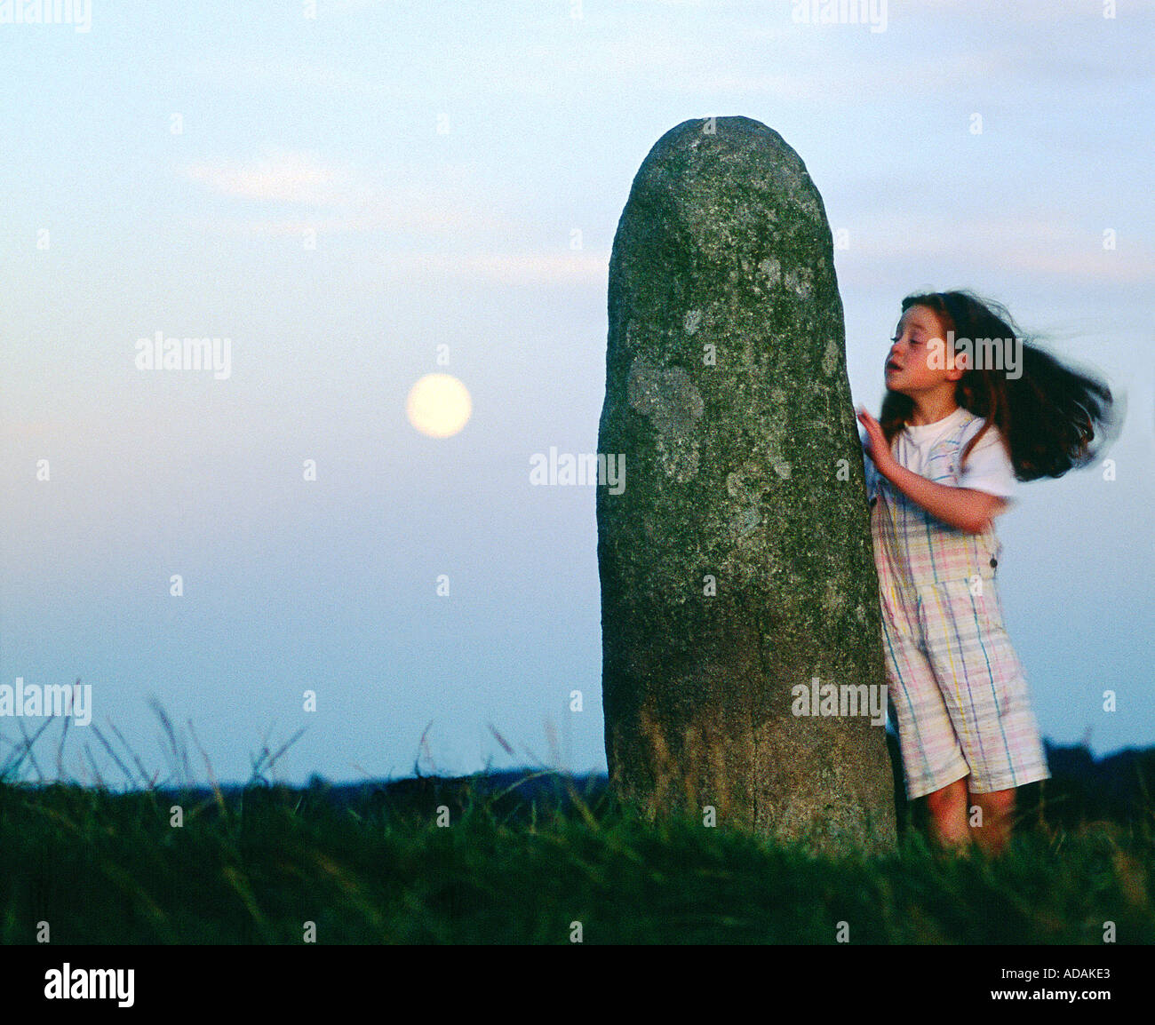 The Lia Fail, crowning stone of the high kings of Ireland, full moon rising. Ancient ritual site of Tara, County Meath, Ireland. Stock Photo