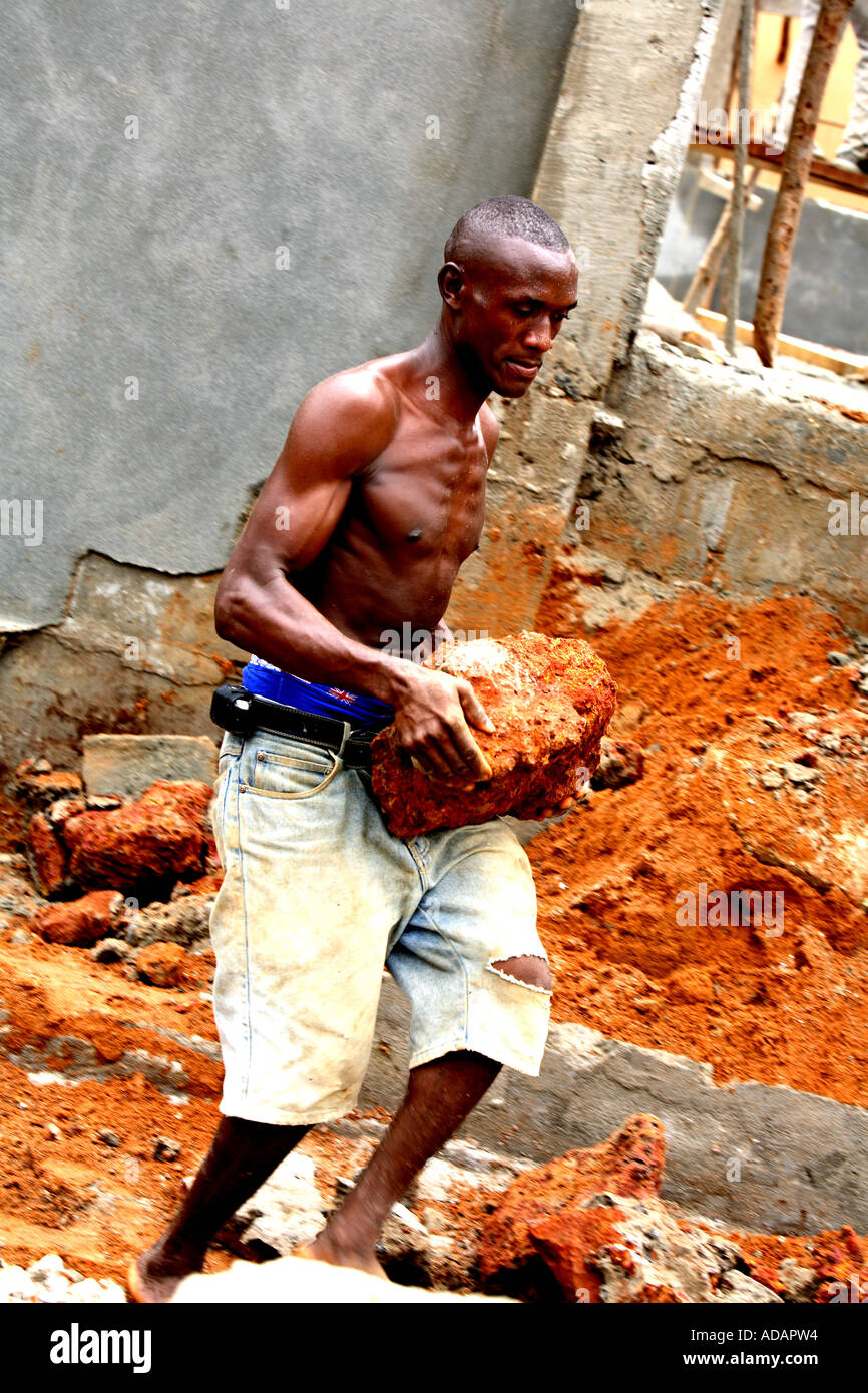 Vertical contrasty environmental portrait of builder in street of Freetown, Sierra Leone, West