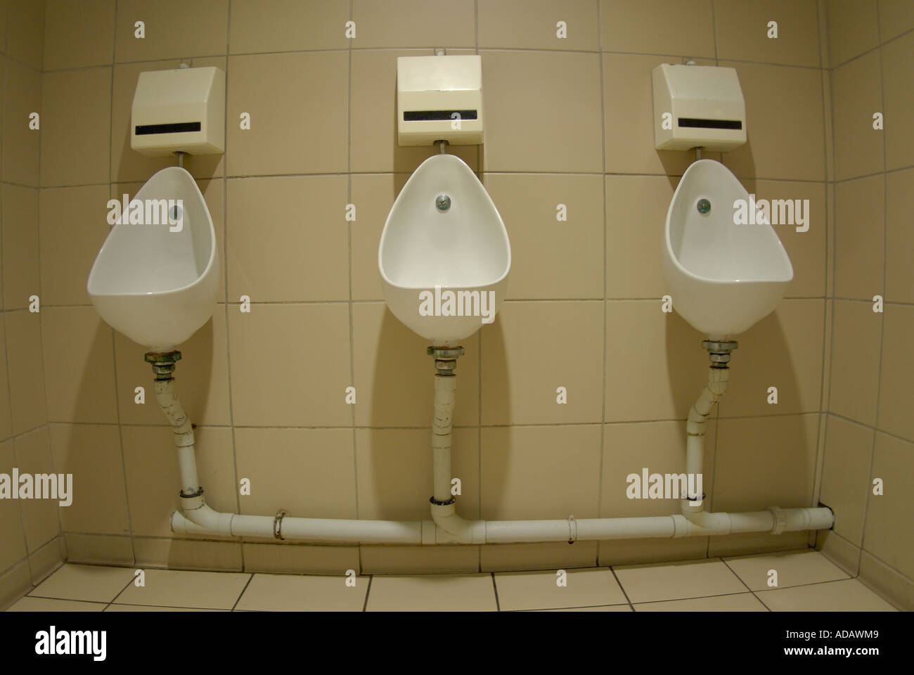 Three urinals in a row in a public bathroom Stock Photo Alamy