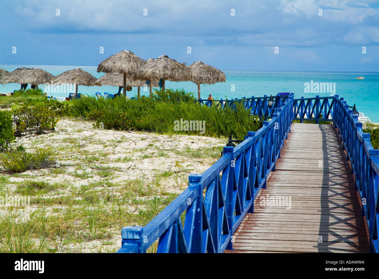 Wooden footbridge heading towards the beach with palm frond shades and beautiful waters, Cayo Santa-Maria, Cuba. Stock Photo