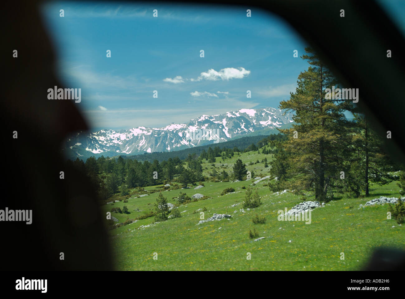 Silhouette of a Man Driving Through Mountainous Terrain Whilst Talking on a Mobile Cell Phone Stock Photo