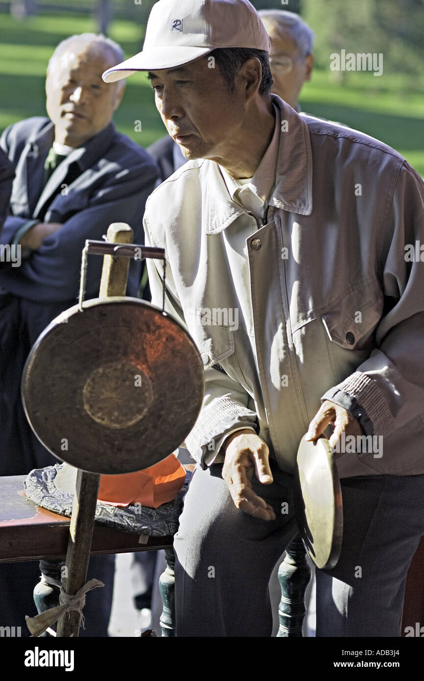 CHINA BEIJING Elderly Chinese gentleman playing the Chinese gong at the Temple of Heaven Park Stock Photo