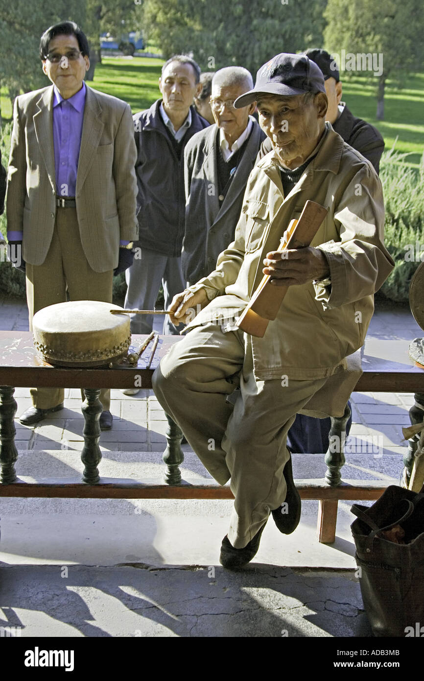 CHINA BEIJING Elderly Chinese gentleman playing both the Chinese drum and the zhu at the Temple of Heaven Park Stock Photo