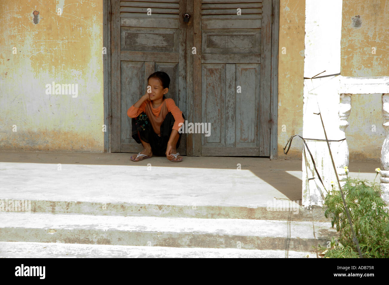 A small thoughtful girl in a shool playground in Cambodia, Kampot Stock Photo