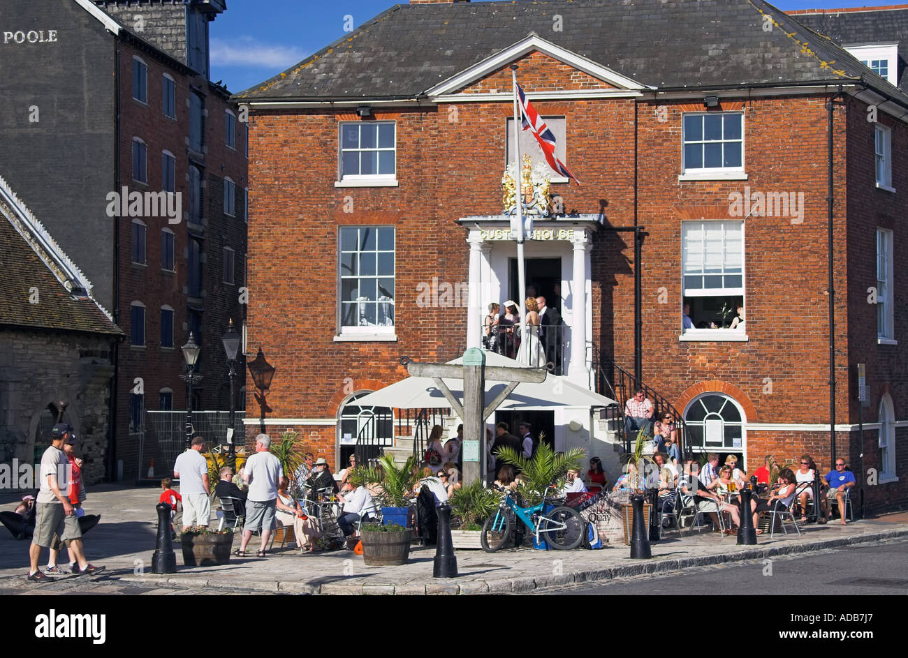 People drinking outside the Old Custom House now converted into a café bar Poole Dorset England Stock Photo