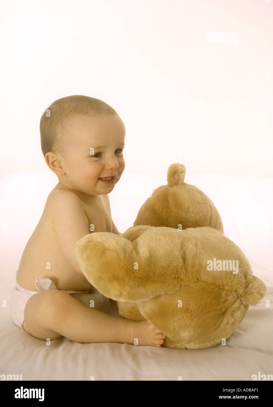 Happy baby boy playing with a teddy bear Stock Photo - Alamy