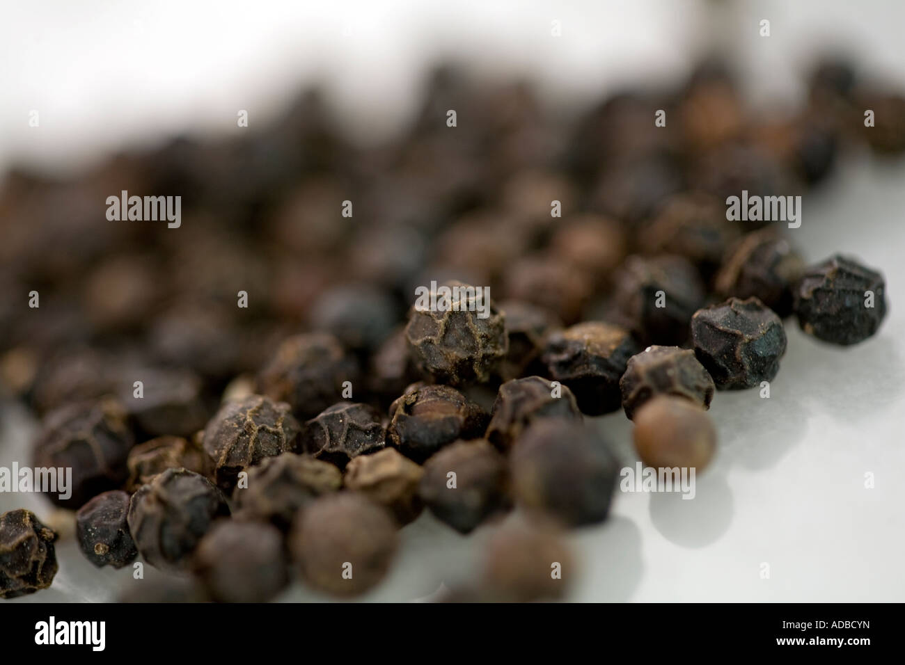 Peppercorns on worktop Stock Photo