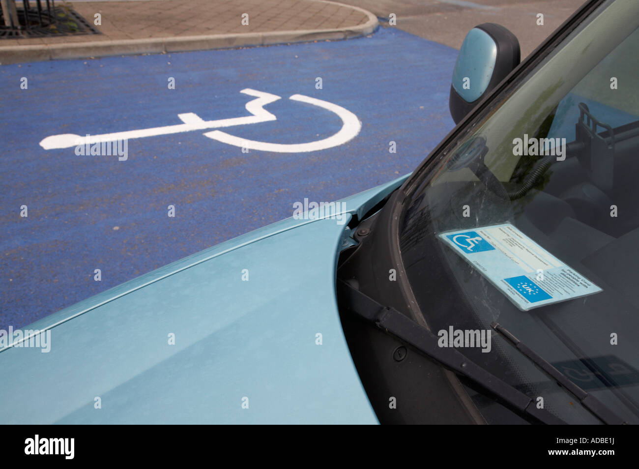 car with eu northern ireland issued parking card for people with disabilities parked in disabled parking bays in car park Stock Photo