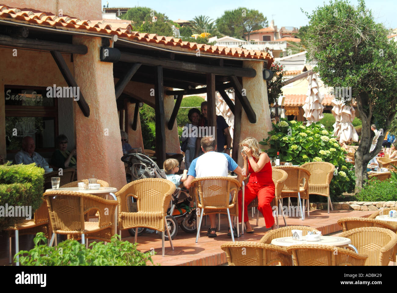 Baia Sardinia waterfront pavement bar holiday family at table Stock Photo