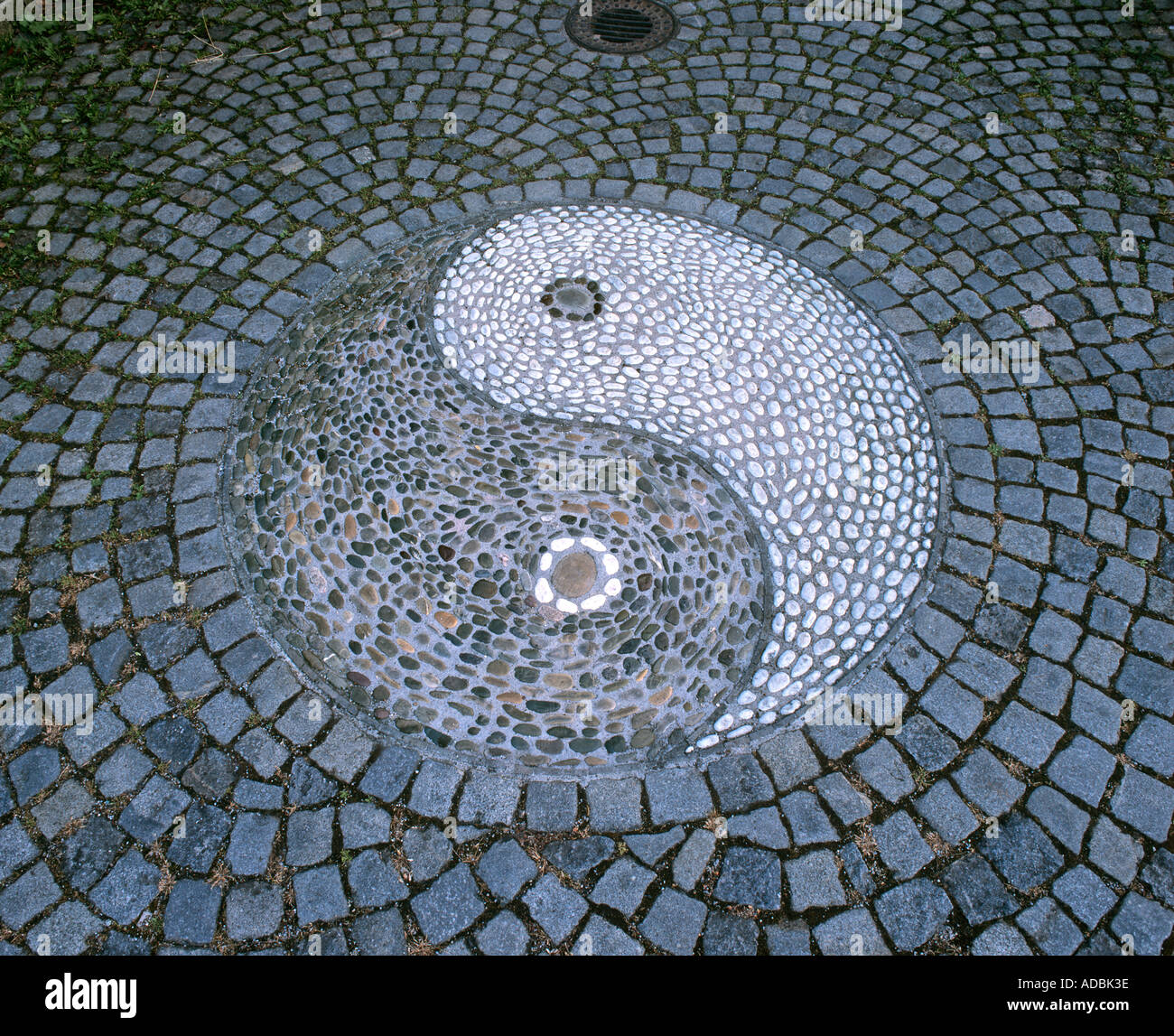 Yin yang symbol constructed of pebbles in the pavement at the entrance to the Chinese Garden, Stuttgart, Germany. Stock Photo