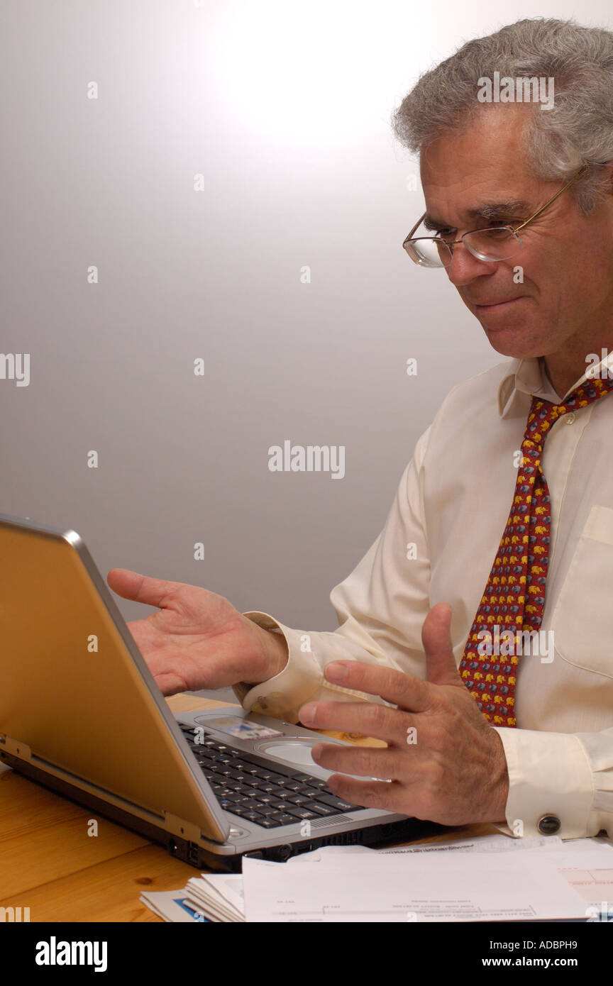 An older businessman. satisfied with some work that he has just done on his computer Stock Photo