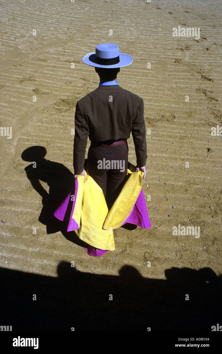 Shadow of  bull fighter/ matador carrying cloak of yellow and purple, Spain Stock Photo