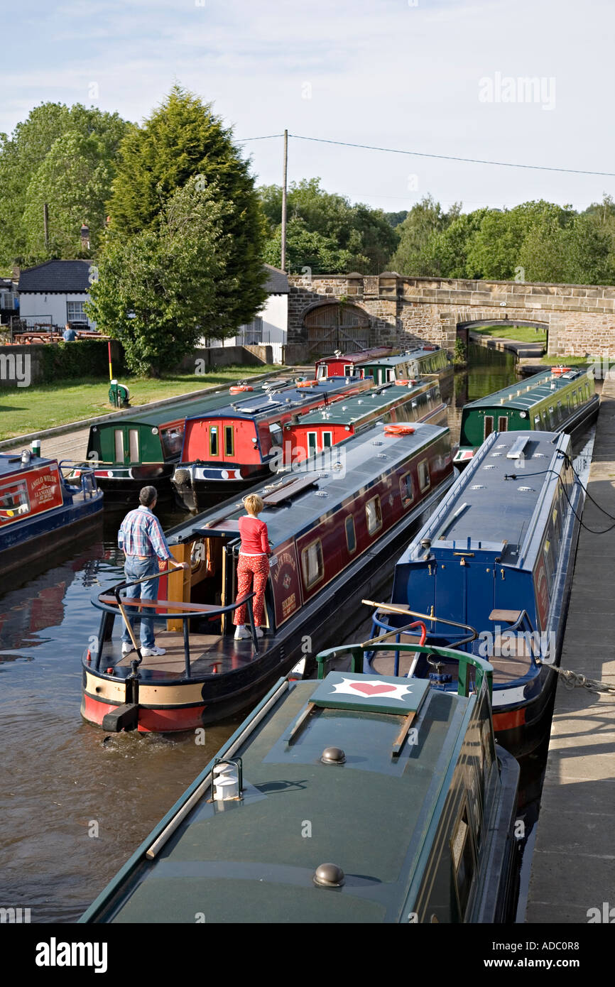 Narrowboat navigating between moored craft in Trevor basin Llangollen canal Pontcysyllte Wales UK Stock Photo