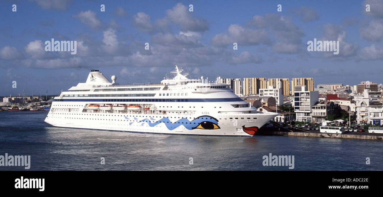 Pointe A Pitre panoramic view of the harbour cruise ship Aida at dockside with town and high rise buildings beyond tropics Stock Photo