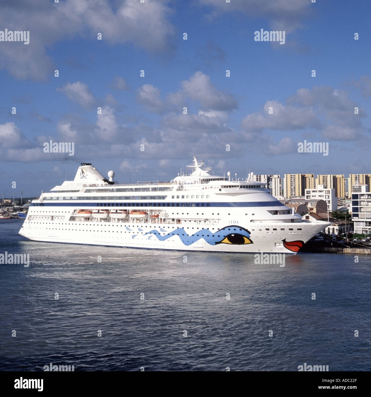 Pointe A Pitre view of the harbour cruise ship Aida at dockside with town and high rise buildings beyond tropics tropical Stock Photo