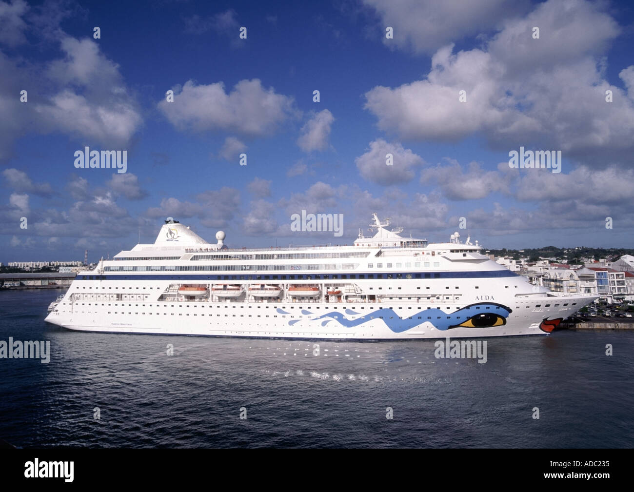 Pointe A Pitre view of the harbour cruise ship Aida at dockside with town and high rise buildings beyond tropics tropical Stock Photo