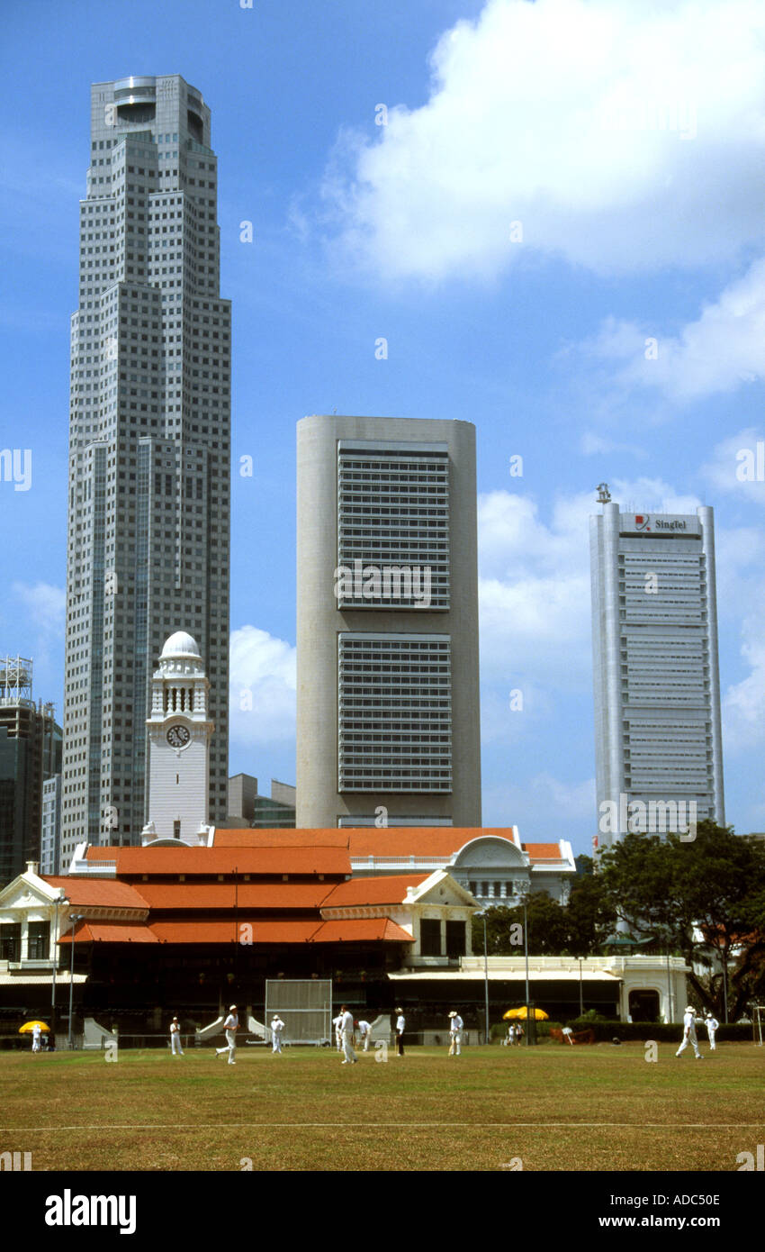 Playing Cricket on the Padang Singapore with city skyline behind old colonial style club house Stock Photo