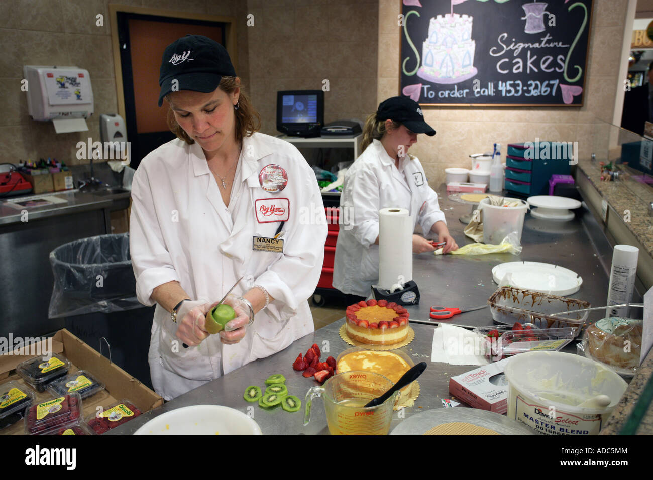 Bakers work in a supermarket bakery making specialty pies and cakes