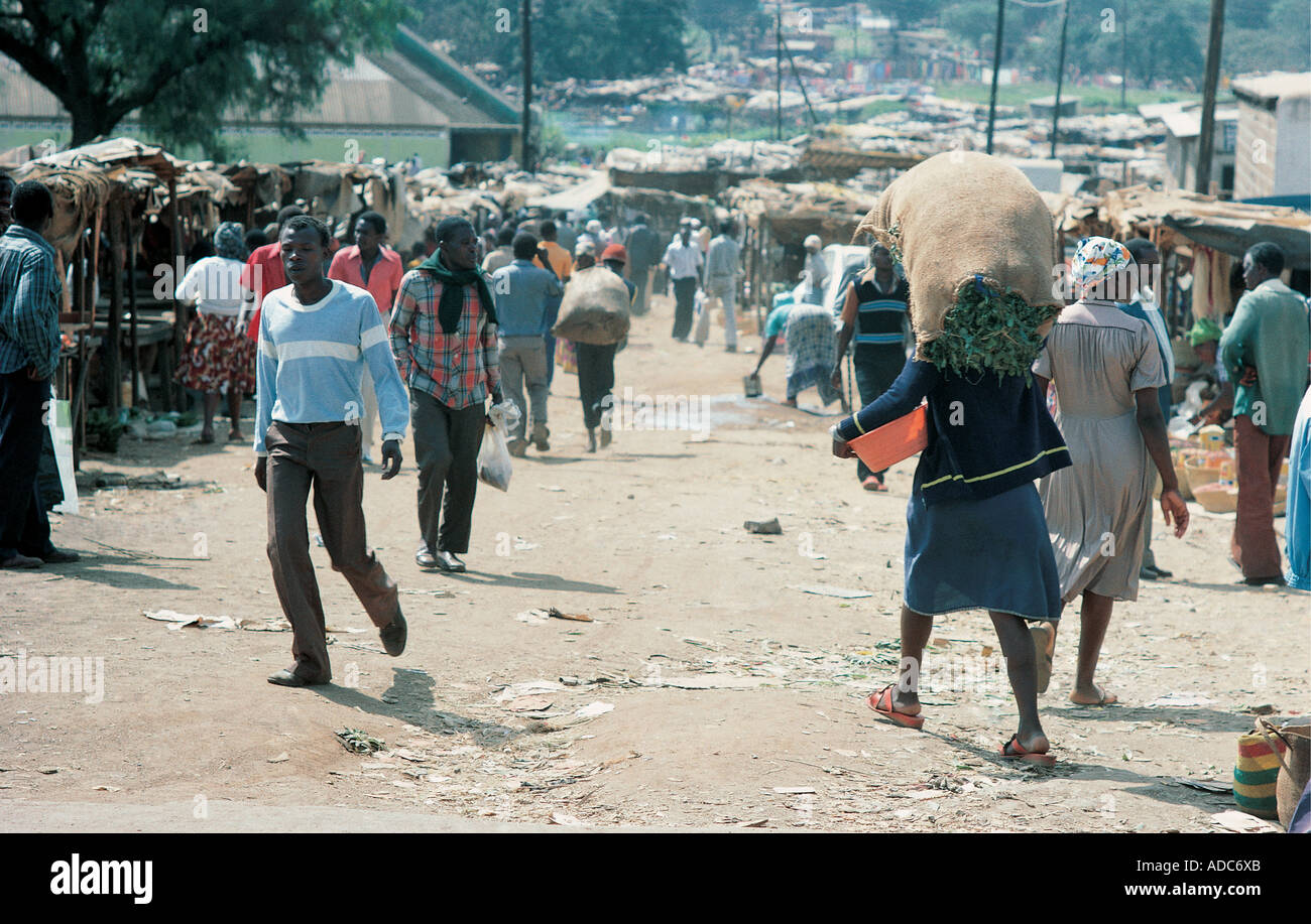A busy unmade dirt street in one of the poor slum areas of Nairobi Kenya East Africa Stock Photo
