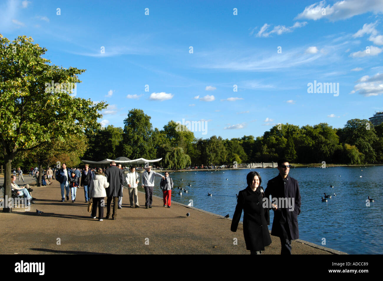 People walking in Hyde Park by the Serpentine London England UK Stock Photo