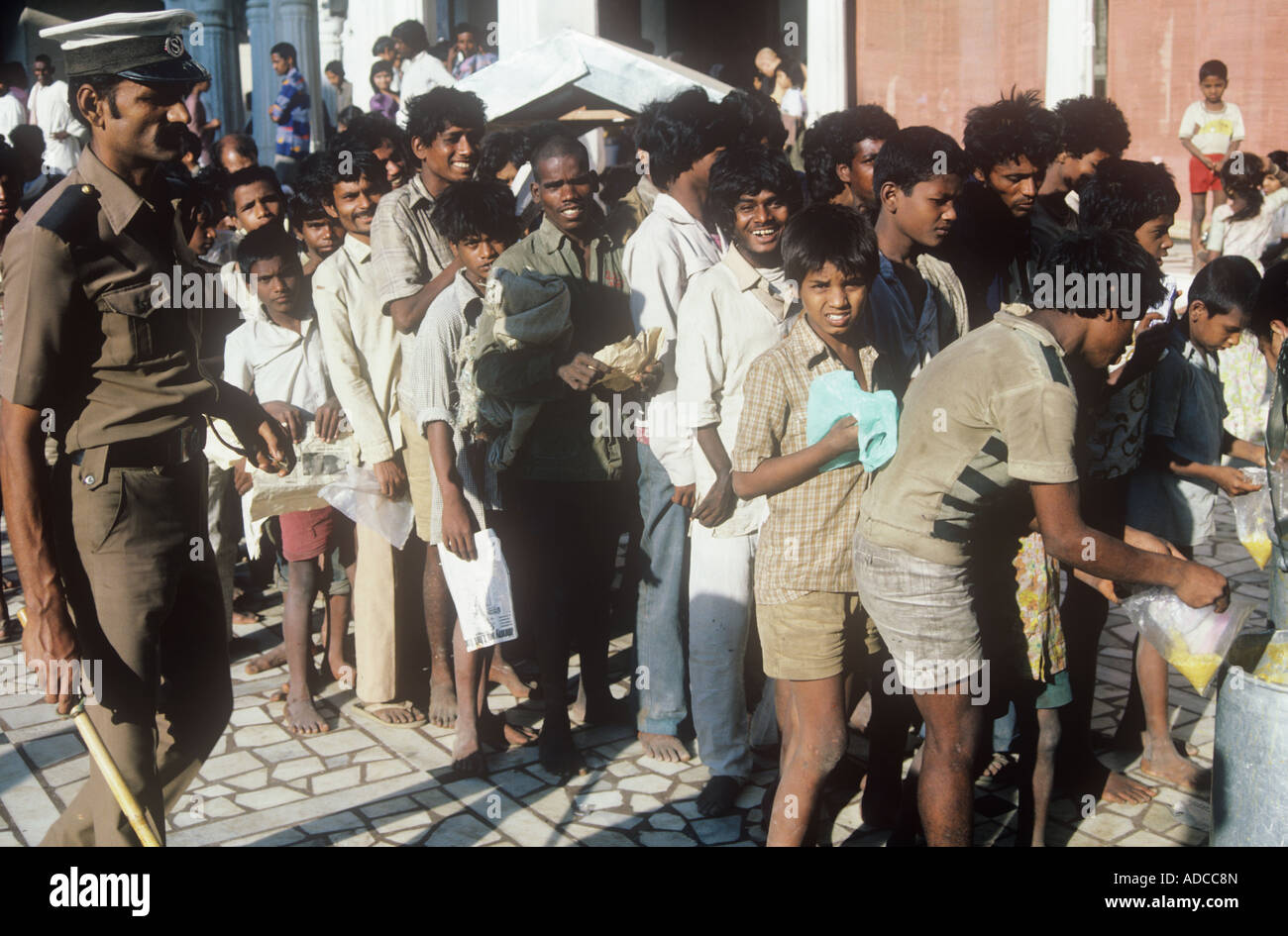 Poor line up to receive food at the Hare Krishna temple in Mumbai India Stock Photo