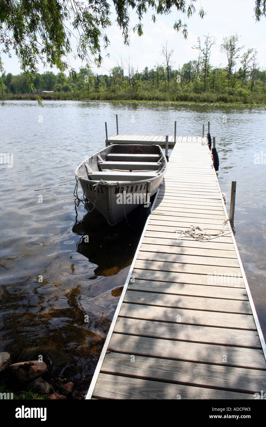 A fishing boat tied to the dock in a lake Stock Photo - Alamy