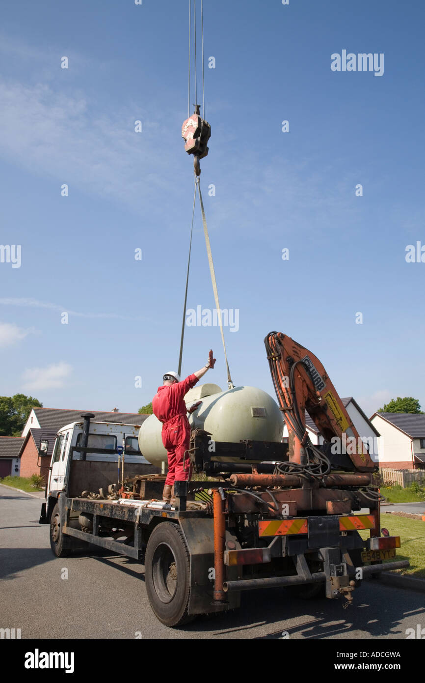 Calor gas tank being lowered on to a lorry by a crane. UK, Britain