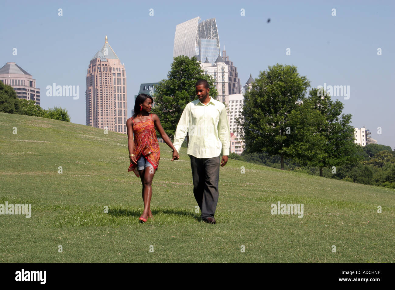 African American couple holding hands and walking toward the viewer ...