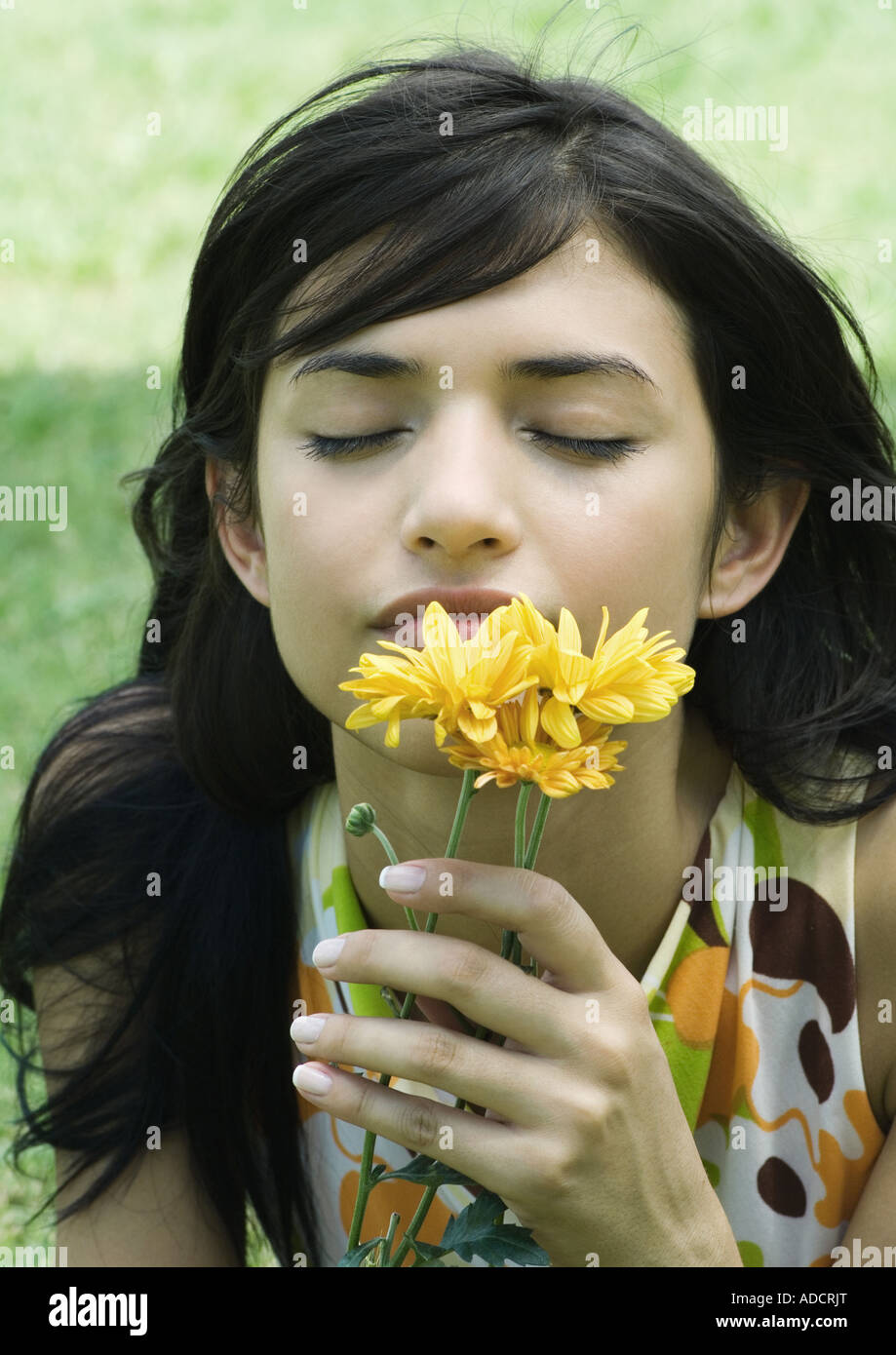 Woman smelling flowers, eyes closed Stock Photo