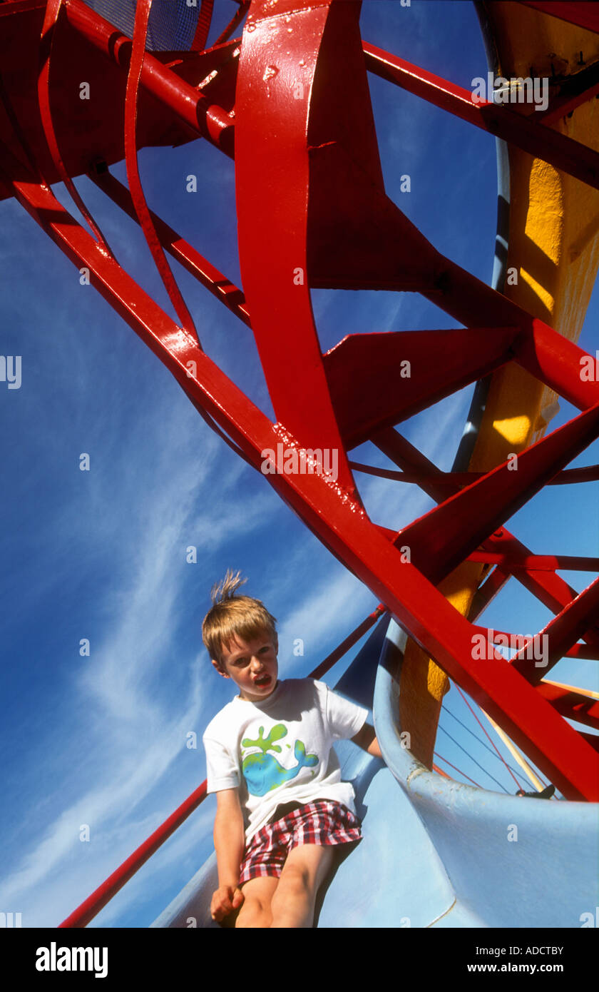 Young boy sliding down Helter Skelter Stock Photo