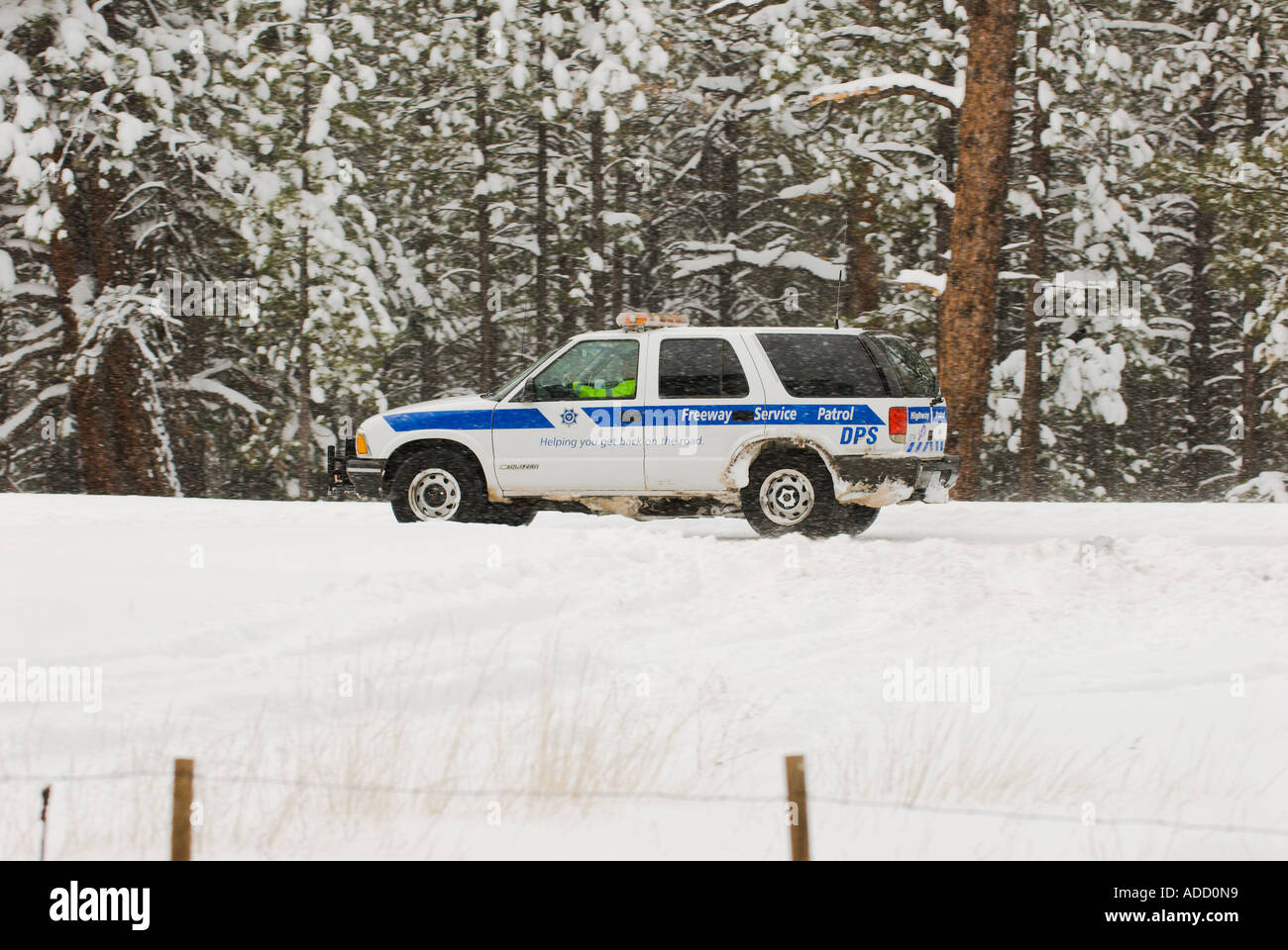 An Arizona Department of Public Safety Vehicle patrols highway 180 during a snow storm in northern Arizona near Flagstaff Stock Photo