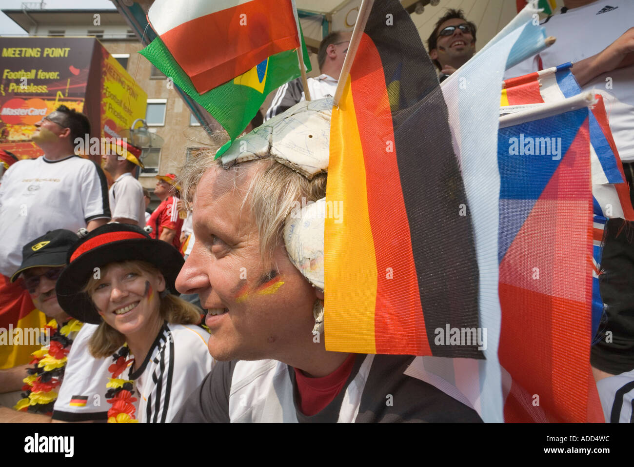 A football fan wearing a has been leather ball with various flags attached as a hat at a football world cup public viewing event Stock Photo