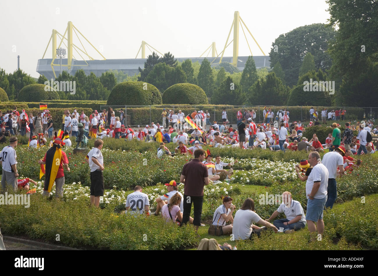 German and Polish football fans waiting together in a park for the world cup match Germany vs. Poland Stock Photo