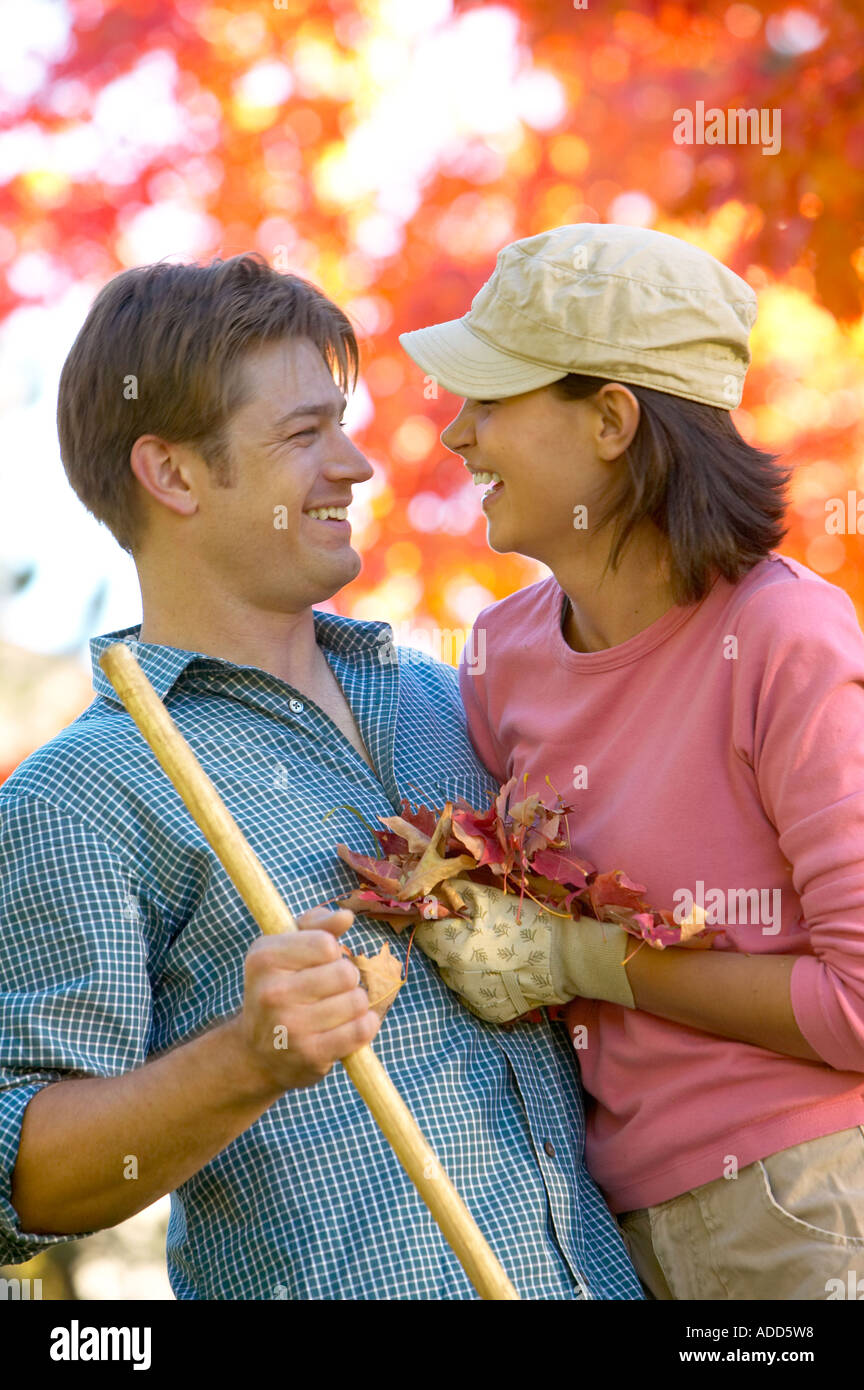 happy early 30's Caucasian couple playing in Autumn leaves Stock Photo