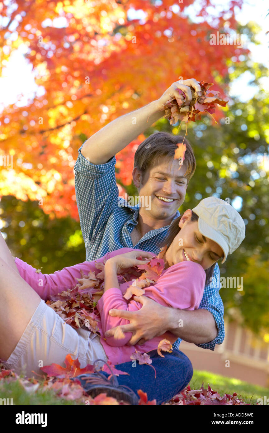 happy early 30's Caucasian couple playing in Autumn leaves Stock Photo