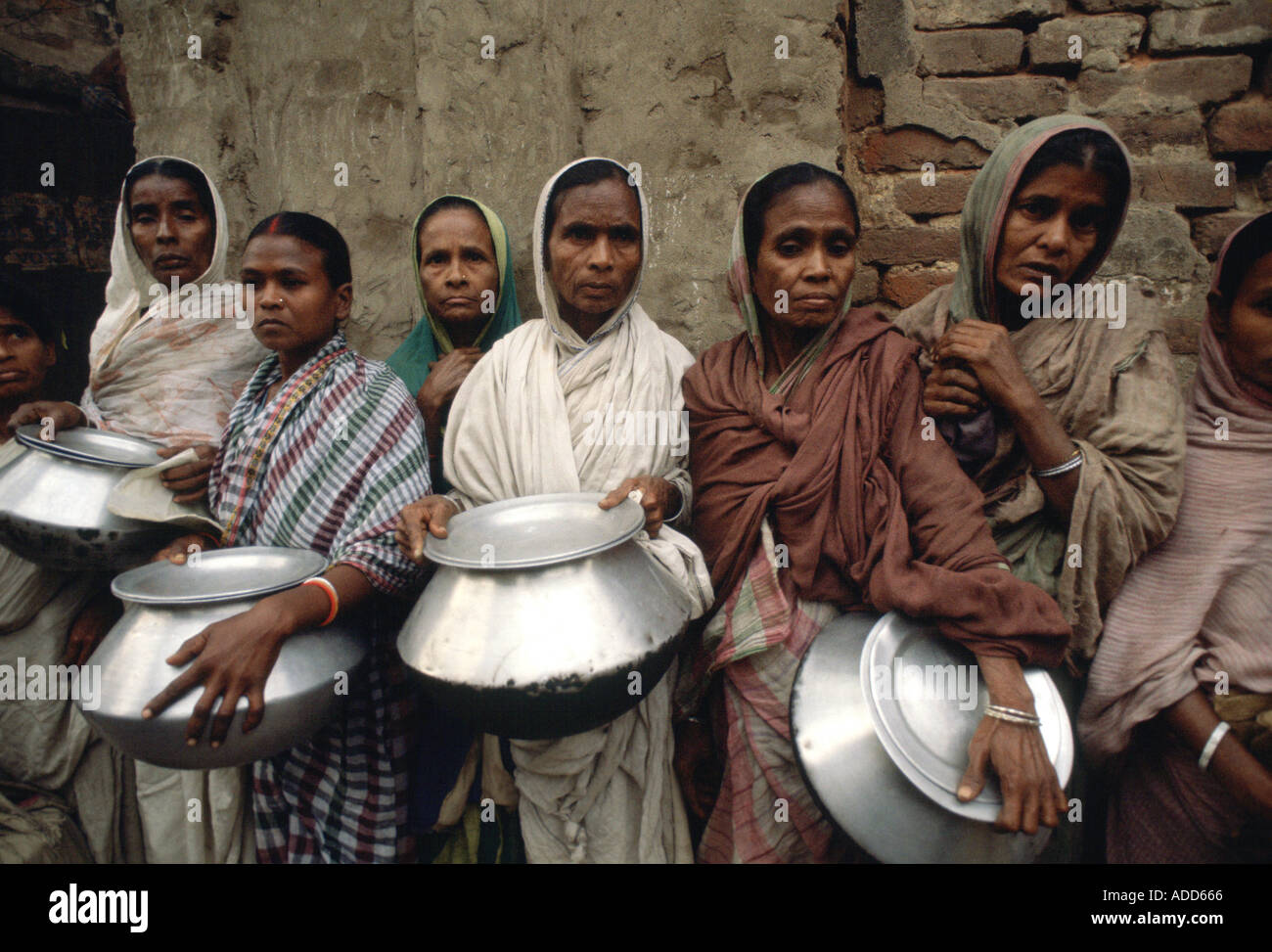 Poor people with pots queuing for food for their families at Mother Teresa s Mission Calcutta India Stock Photo