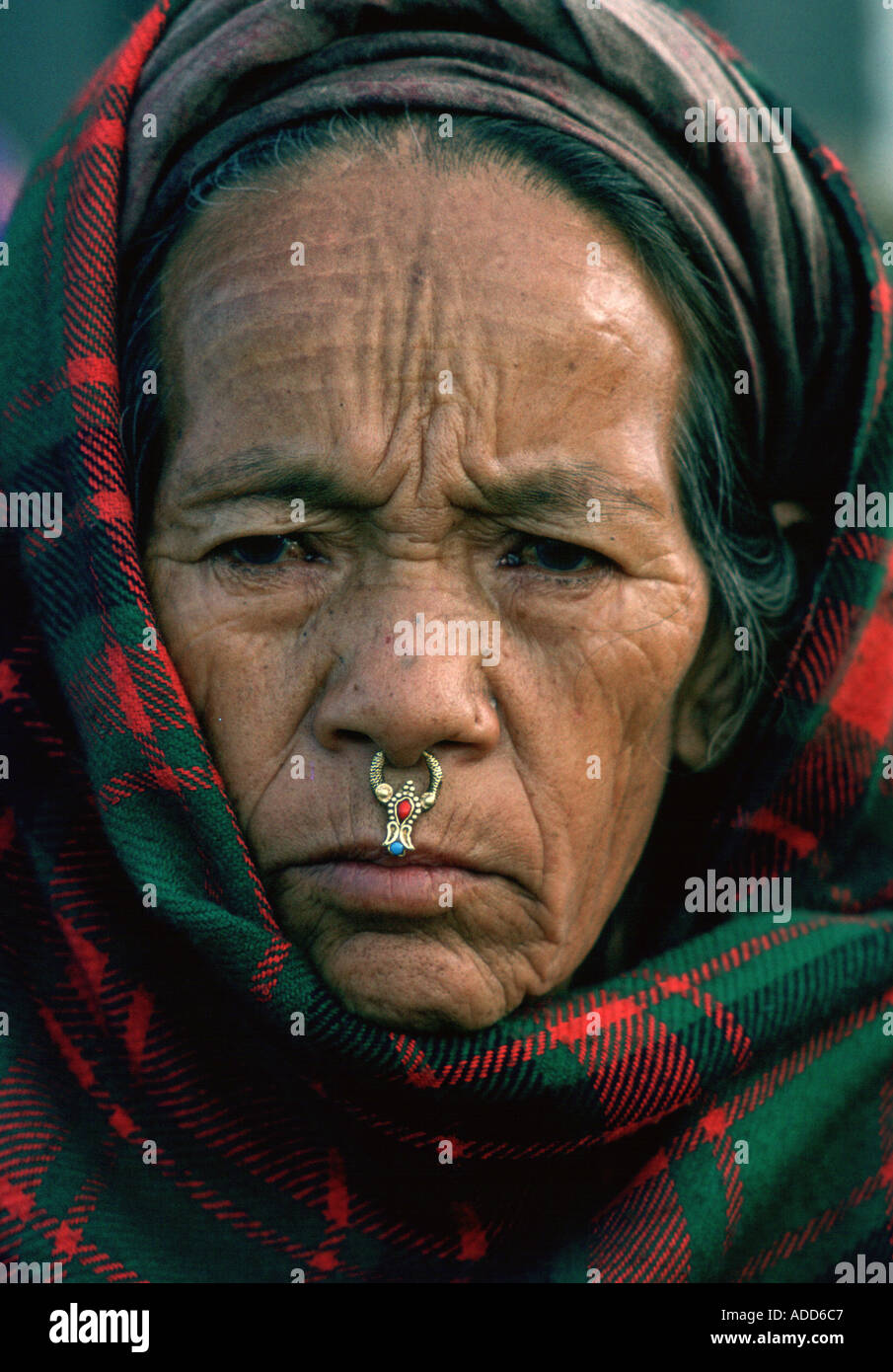 Woman from Kathmandu valley Nepal with nose jewels and head is covered with tartan shawl Stock Photo