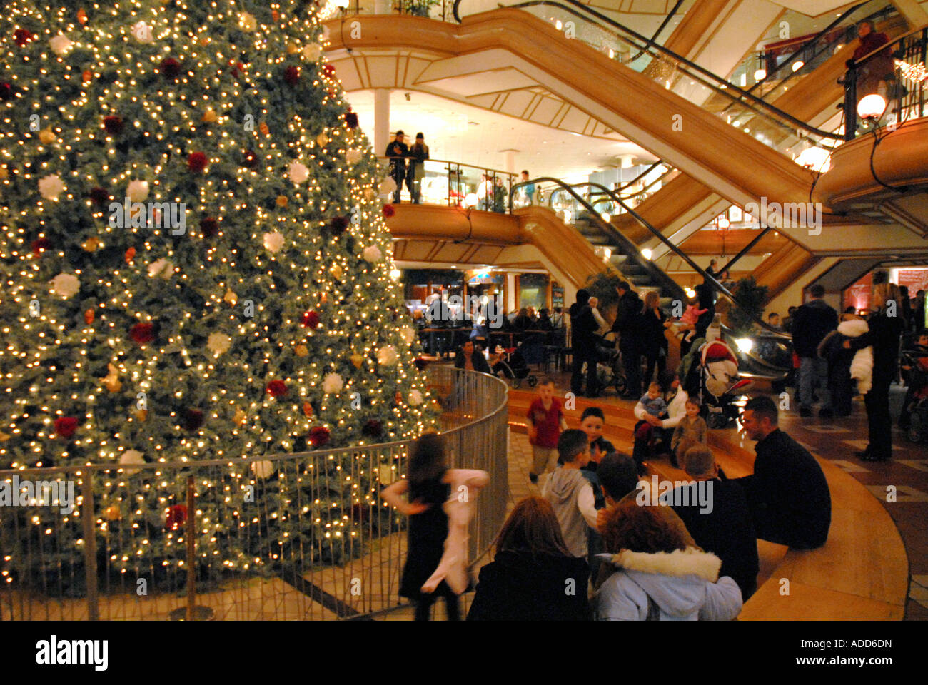 People Sitting around Christmas Tree, Princes Square Shopping Centre, Glasgow.Scotland. Christmas Eve December 2006 Stock Photo